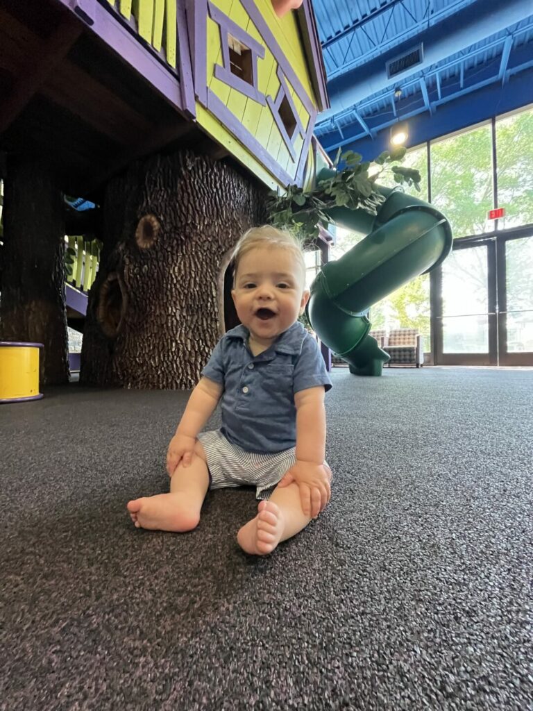 A smiling baby playing at a dental office