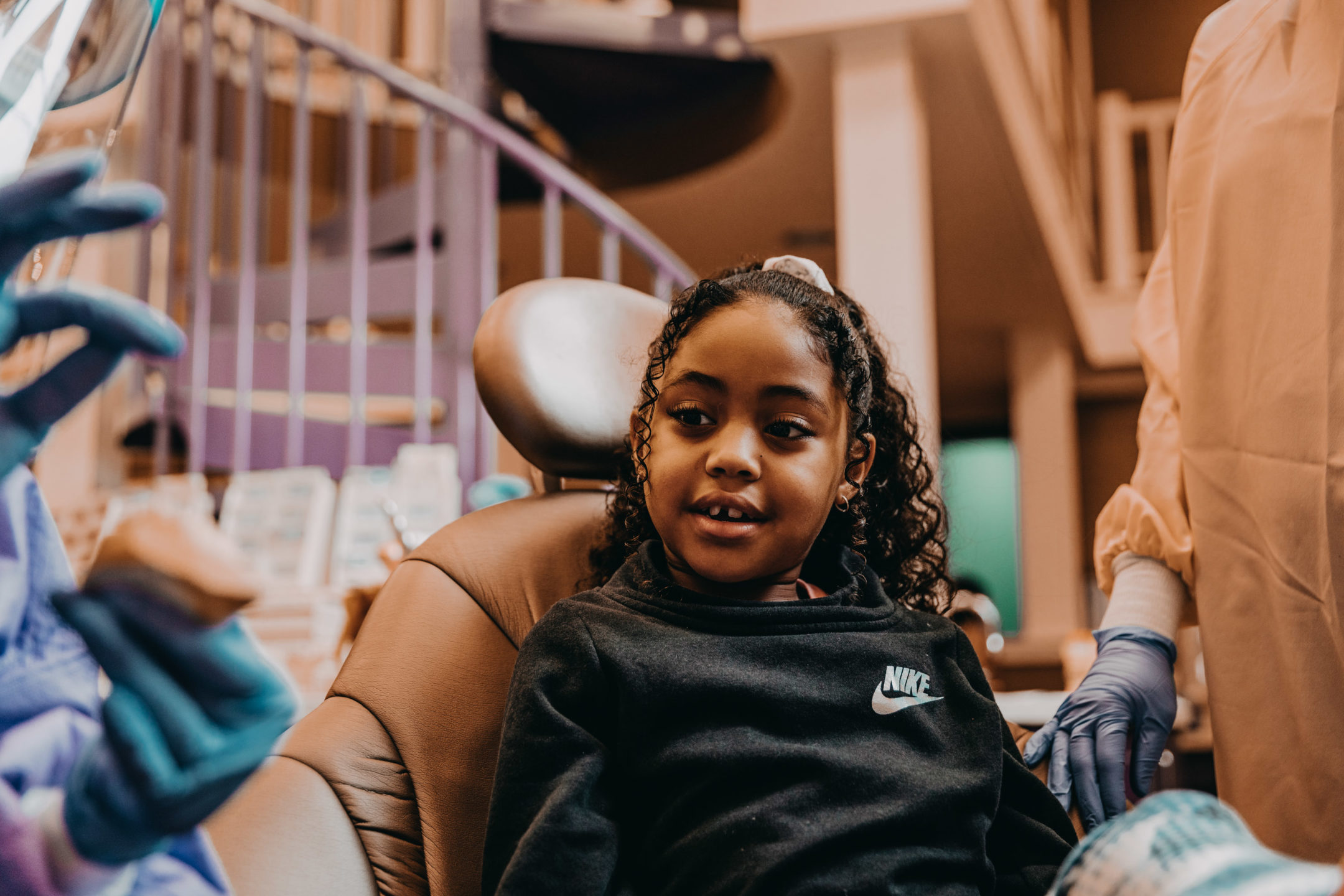 Young smiling patient sitting in a dentist chair in a calm, welcoming dentist office.