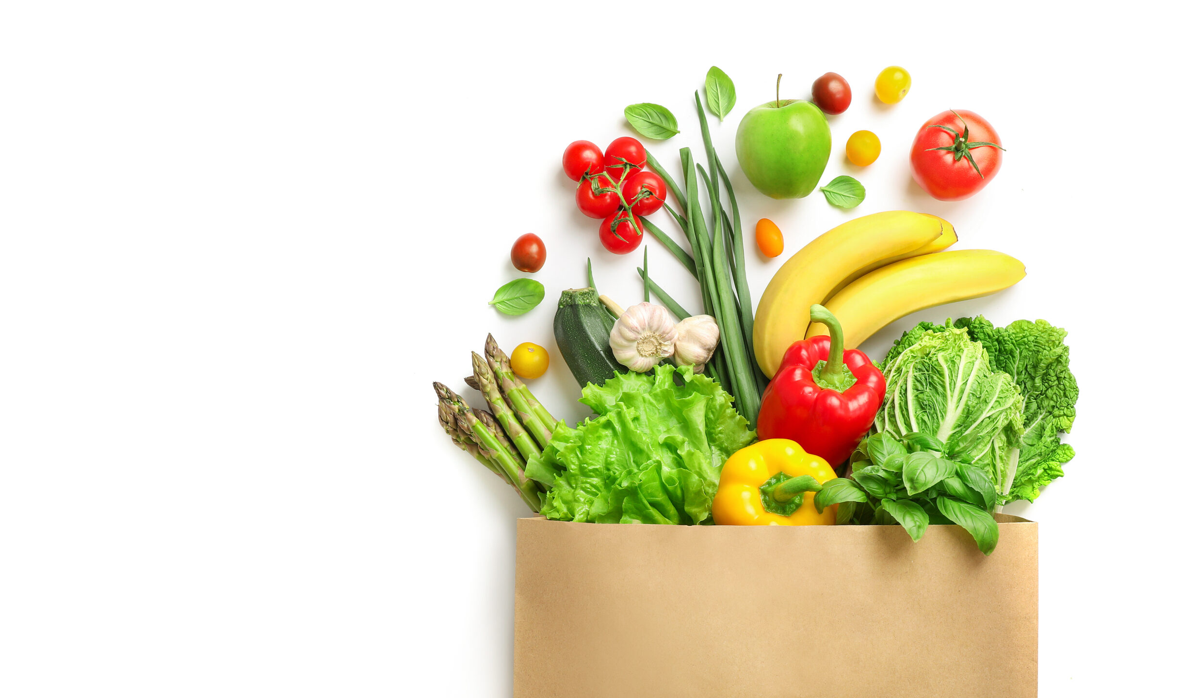  Image of a bag full of fresh brightly-colored fruits and vegetables.