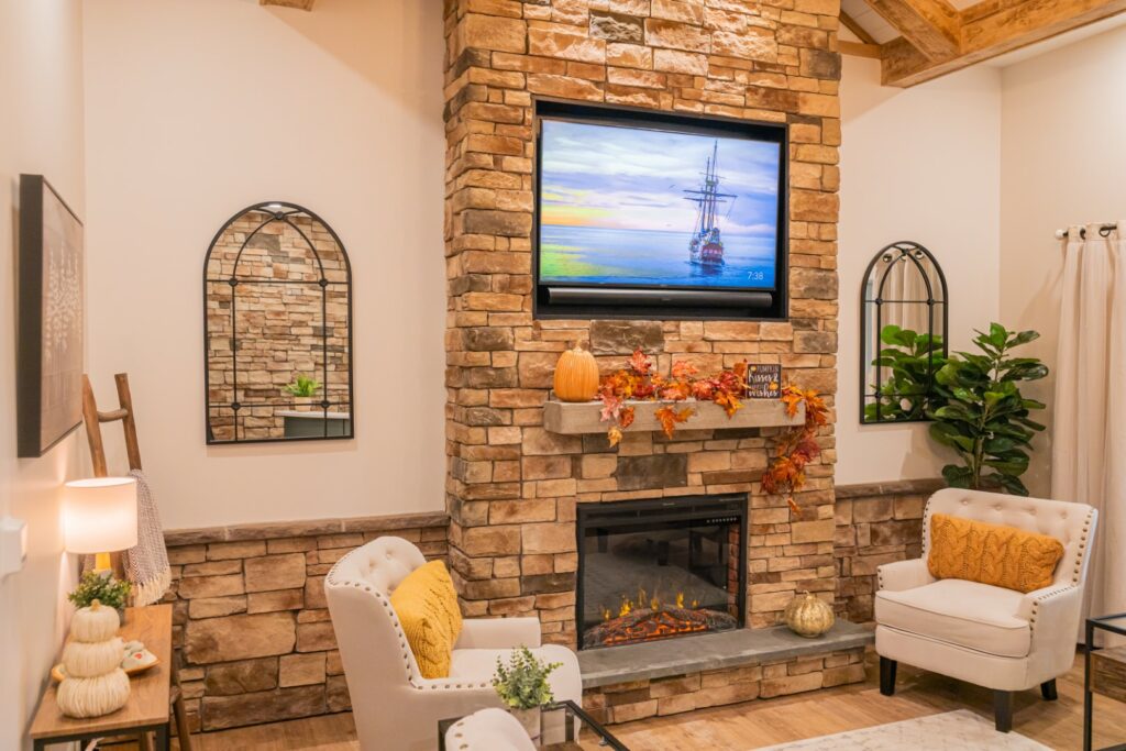 Image of waiting room of adult dental practice, with stone fireplace and big-screen TV on the wall.
