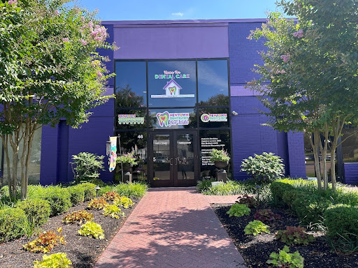 Photo of bright purple building with landscaped sidewalk.